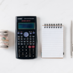 Illustration de l'article sur le calcul du coût du salaire en france par le geyvo groupement d'employeurs : de l'argent liquide, une calculatrice casio, un bloc note et un crayon